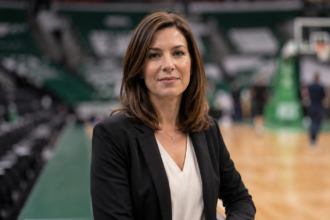Kathleen Nimmo Lynch inspired professional woman standing inside a basketball arena with a blurred court background